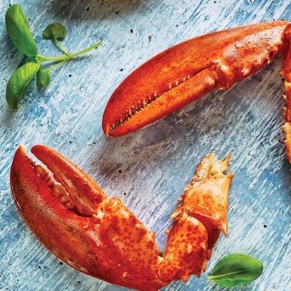 Cooked lobster claws with golden seasoned shell, premium seafood item ideal for catering trays and celebration dining.
